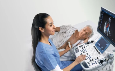 lekarz bada klatkę piersiową pacjenta aparatem usg GE Vivid, pacjent leży bokiem